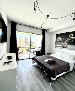 a bedroom with a large bed and a large window at Cozy Apartment with Sea and Mountain Views in Benidorm in Benidorm