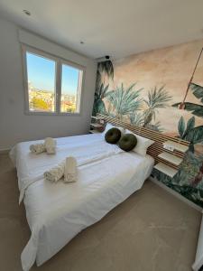 ein großes weißes Bett in einem Zimmer mit Wandgemälde in der Unterkunft Vista Mar in San Pedro del Pinatar