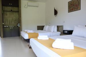 a hotel room with two beds with towels on them at Handagedara Resort & Spa in Mirissa