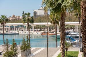 a marina with palm trees and a boat in the water at iloftmalaga Puerto in Málaga