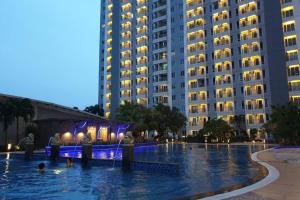 a large swimming pool in front of a large building at Apartment Orchard Tanglin Pakuwon Mall in Surabaya +2 photos