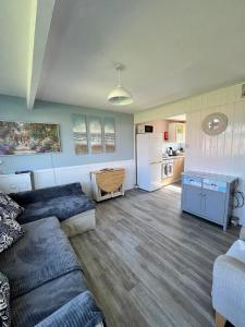 a living room with a couch and a kitchen at California Beach Chalet in Great Yarmouth