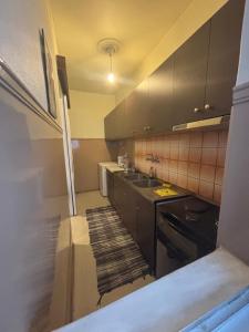 a kitchen with black cabinets and a sink at Studio in Ptolemaida in Ptolemaida +3 photos