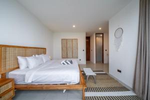 a bedroom with a large white bed and a table at Exquisite New Villa with Unmatched Amazing Views, Huge Pool - 4 Elegant Bedrooms! in Canggu