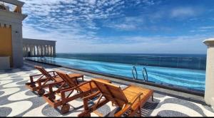 a group of chairs sitting next to a swimming pool at Hillside apartment sunset town city in Phú Quốc