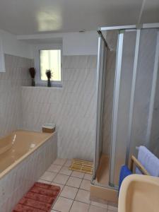 a bathroom with a tub and a shower at La petite maison dans la prairie in Plélan-le-Grand