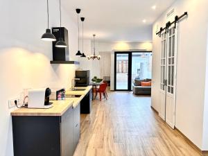 een keuken met een aanrecht en een woonkamer bij Mediterranean Apartament in Valencia