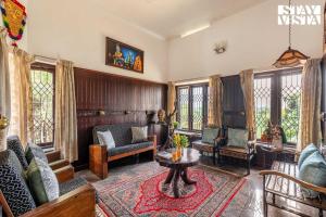 a living room with a couch and chairs and a table at StayVista at Lakshmipuram Palace with Pool,WiFi in Kottayam