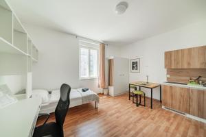 a bedroom with a bed and a desk in a room at Central City Suits in Wiener Neustadt