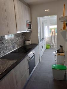a kitchen with white cabinets and a green stool at Apartamento de 3 habitaciones in Getafe