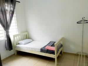 a small bed in a room with a window at iERYN HOMESTAY in Bemban +3 photos