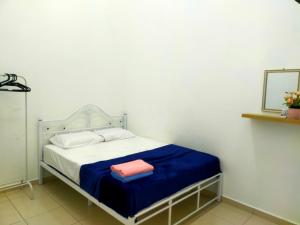 a small bedroom with a bed with a blue blanket at iERYN HOMESTAY in Bemban