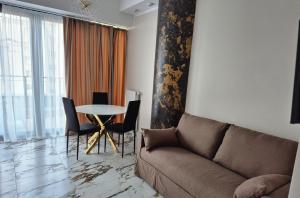 シュチェチンにあるApartament HANZA TOWER - POOL and SPA, no 601のソファとテーブルと椅子のあるリビングルーム