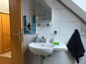 a white bathroom with a sink and a mirror at Gemütliche Ferienwohnung in Wiershop in Wiershop +11 photos