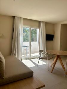 a room with a bed and a table and a window at Serena Sol Apartments - Adults Only - Over 12 in Cala Serena