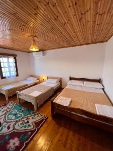 a bedroom with two beds and a wooden ceiling at Villa Maria - Berat Castle in Berat