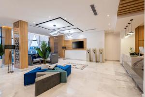 an office lobby with blue couches and a tv at Al Qasr Hotel Al Rabwah in Abha