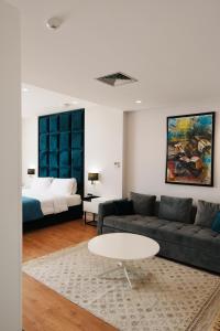 a living room with a couch and a table and a bed at Hotel Blue Sky in Sarandë