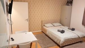 a bedroom with a bed and a table and a desk at Diamond Home Apartments in Vienna