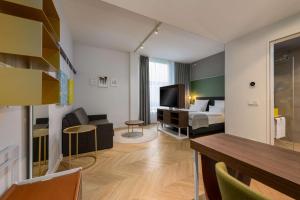 a hotel room with a bed and a living room at Flightgate Munich Airport Hotel, a member of Radisson Individuals in Hallbergmoos
