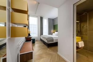 a hotel room with a bed and a mirror at Flightgate Munich Airport Hotel, a member of Radisson Individuals in Hallbergmoos +84 photos
