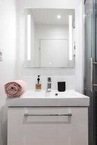 a white bathroom with a sink and a mirror at Le Concon Rose - Hyperb centre - Clim - WIFI & Netflix in Toulouse