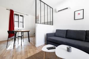 a living room with a couch and a table at Le Concon Rose - Hyperb centre - Clim - WIFI & Netflix in Toulouse