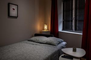 a bedroom with a bed and a table and a window at Le Concon Rose - Hyperb centre - Clim - WIFI & Netflix in Toulouse
