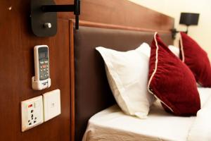 a room with a bed with red pillows and a phone at Hotel Harmony in Kathmandu