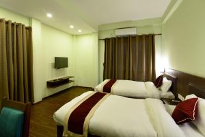 a hotel room with two beds and a television at Hotel Harmony in Kathmandu