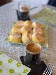 a cup of coffee next to a plate of donuts at Sheraton Luxury Villa in Baku +6 photos