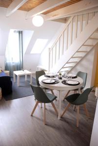 ein Esszimmer mit einem weißen Tisch und Stühlen in der Unterkunft El pisito Quimperois duplex 2 chambres coeur de ville in Quimper