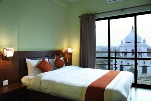 a bedroom with a bed and a large window at Hotel Harmony in Kathmandu