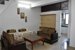 a bedroom with a bed and a couch and a chair at Sharma in Shimla