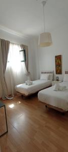 sypialnia z dwoma łóżkami i oknem w obiekcie Casas y Patios de Sevilla w Sewilli