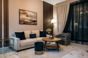 a living room with a couch and a table at Fabulous Brand New 1BR, Gym Pool & Balcony in Ras al Khaimah