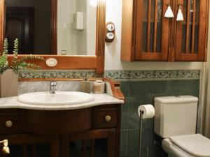 a bathroom with a sink and a toilet at Casa Mari Carmen in Salas +26 photos
