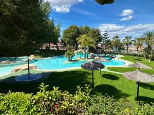 a swimming pool with umbrellas in a resort at Casa Monte y Faro in Santa Pola