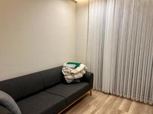 a living room with a black couch and a window at Green Park Villa in Kemer