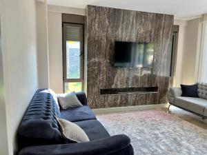 a living room with a blue couch and a tv at Green Park Villa in Kemer +24 photos