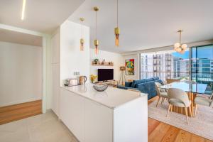 Una cocina y una sala de estar con un sofá y una mesa. en Bayline Condominium - Heated indoor Swimming pool - SPA - By Bedzy, en Armação de Pêra