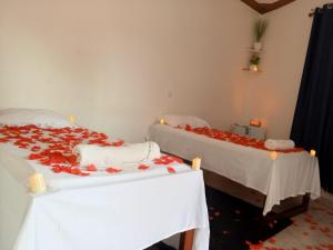 two beds with red flowers on them in a room at Noaz Hotel in Bulambiro