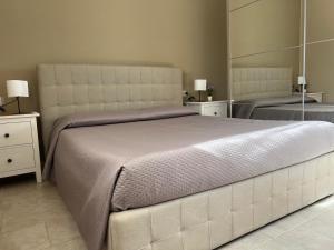 een slaapkamer met een groot bed en een grote spiegel bij Villa Lucrezia in San Vito dei Normanni