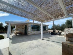 een buitenterras met een houten pergola bij Villa Lucrezia in San Vito dei Normanni