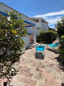 a patio with a blue chair and a house at Villa Ingrosso in Leporano Marina