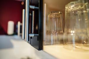 a row of wine glasses sitting on a shelf at Maisonette Apartment mit Panorama Terrasse in Kaiserslautern WeHome Premium in Kaiserslautern +55 photos