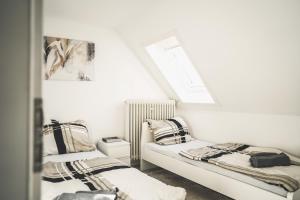 a white room with two beds and a window at Maisonette Apartment mit Panorama Terrasse in Kaiserslautern WeHome Premium in Kaiserslautern
