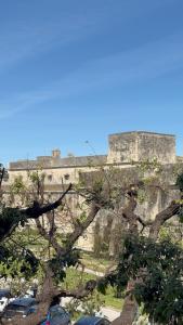 un castello in cima a una scogliera con auto parcheggiate di Lumiae Suite a Lecce