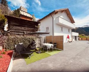 a patio with a table and chairs and a building at Apart Steffi in Fliess
