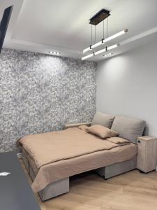a bedroom with a bed and a wall at Inamstro Home in Orhei